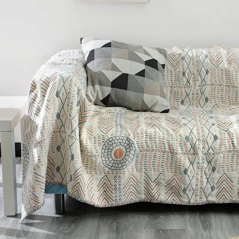 Tribal beige quilted cotton sofa throw blanket featuring geometric and tribal patterns in gray peach and black