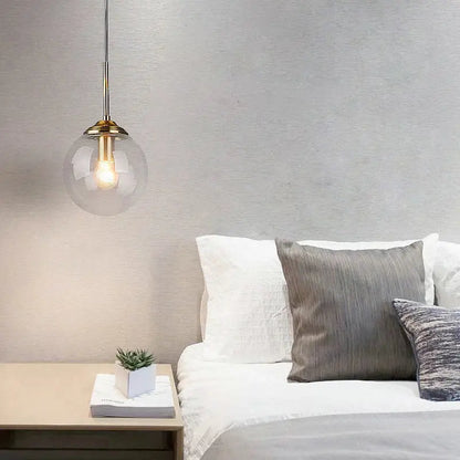 Trio multi tone glass pendant light with polished steel and brass accents hangs above the bed in dining room