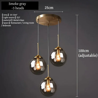 Smoke gray three-head pendant light with brass accents and glass globe shades in polished steel for dining room