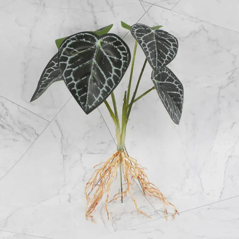 Tropical artificial plant wall set featuring black and white patterned glossy leaves with green stems and tan roots