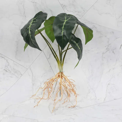 Artificial alocasia plant with dark green leaves and light veins in a tropical plant wall set for living room decor
