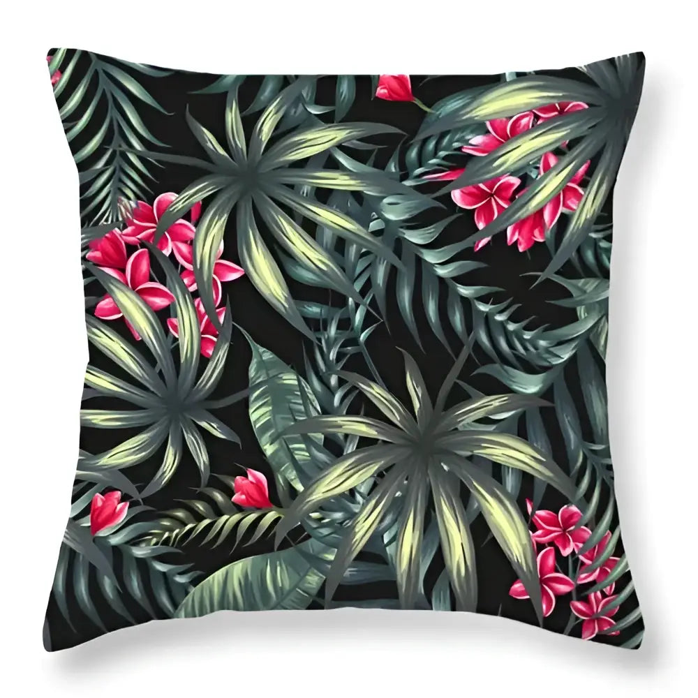 Black throw pillow with vibrant tropical green leaves decorative pattern and pink flowers for home decor