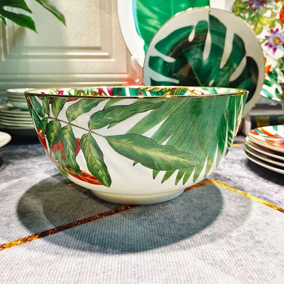 A white porcelain bowl with a gold rim and vibrant green leaf patterns enhancing the green leaf collection dining experience