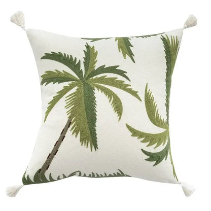 White cushion cover with embroidered patchwork green palm trees and cream tassels for tropical living room decor