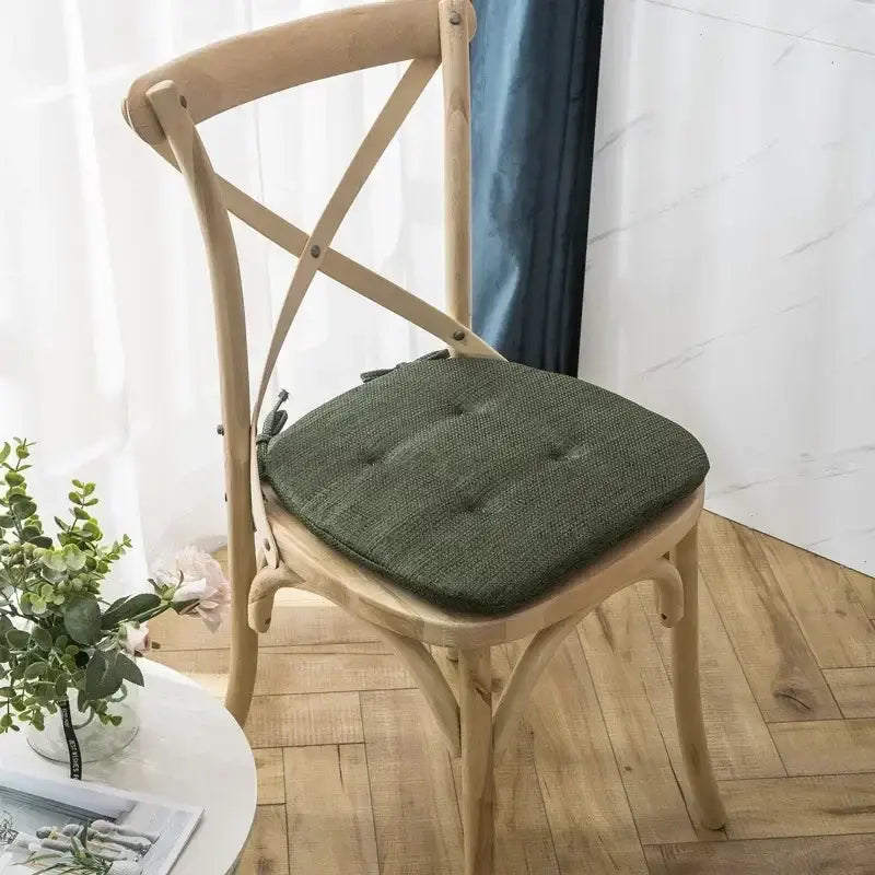 Olive green tufted woven fabric chair cushion on light wood cross-back decorbites dining chair for dining room use