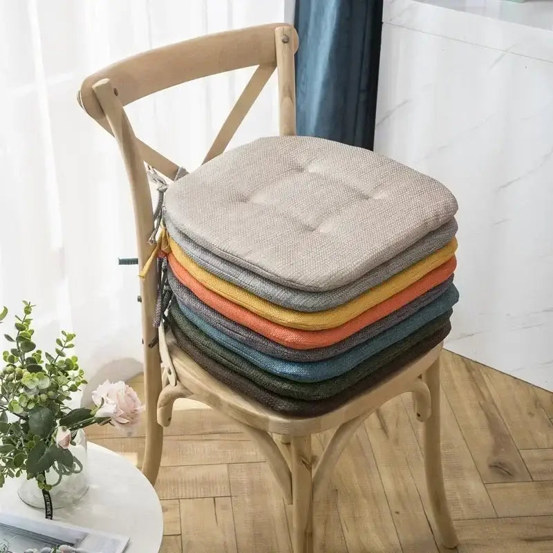 Stack of tufted beige textured fabric dining chair cushions in neutral warm tones for decorbites dining chair use