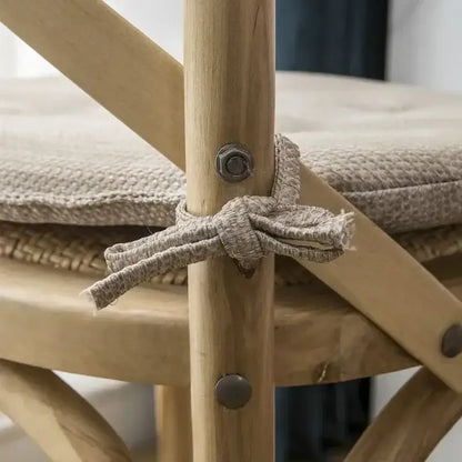 Beige woven fabric tie securing tufted beige textured dining chair cushions on wooden frame of decorbites dining chair