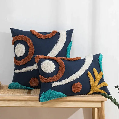 Navy blue cushion cover with tufted tassels and abstract rust cream teal yarn accents from decorbites boho style decor