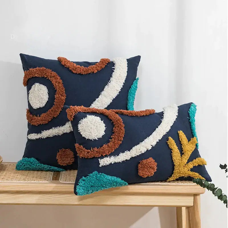Navy blue cushion cover with tufted tassels and abstract rust cream teal yarn accents from decorbites boho style decor
