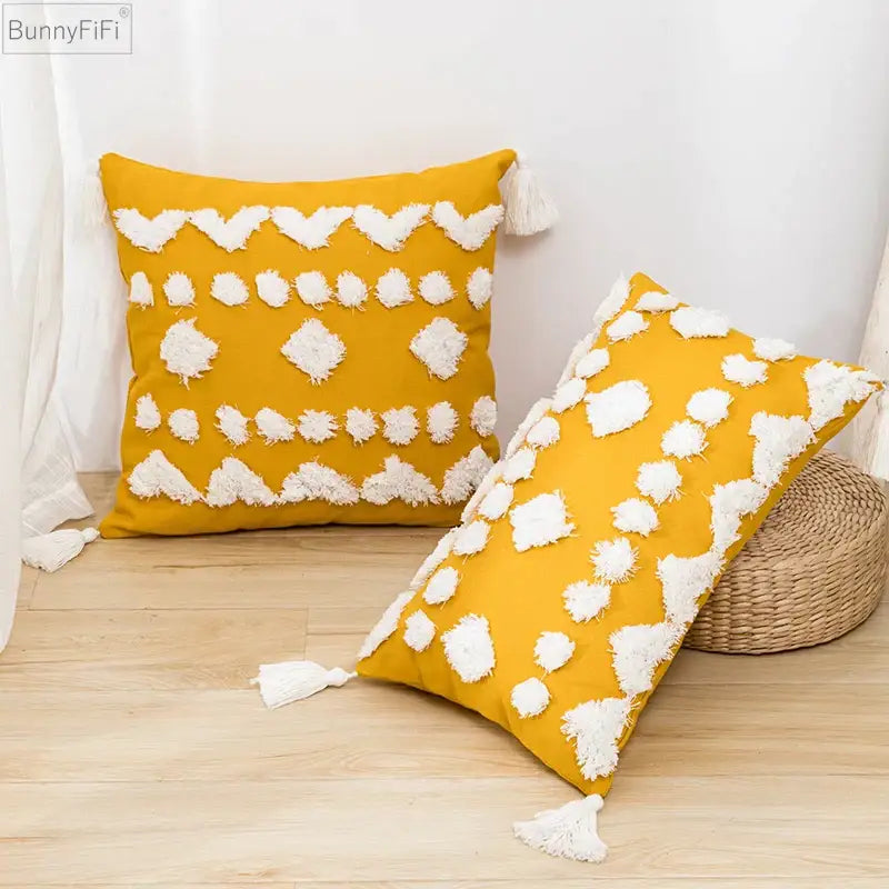 Vibrant mustard-yellow cushion cover with white tufted tassels and geometric fringe accents for decorbites boho style living room decor