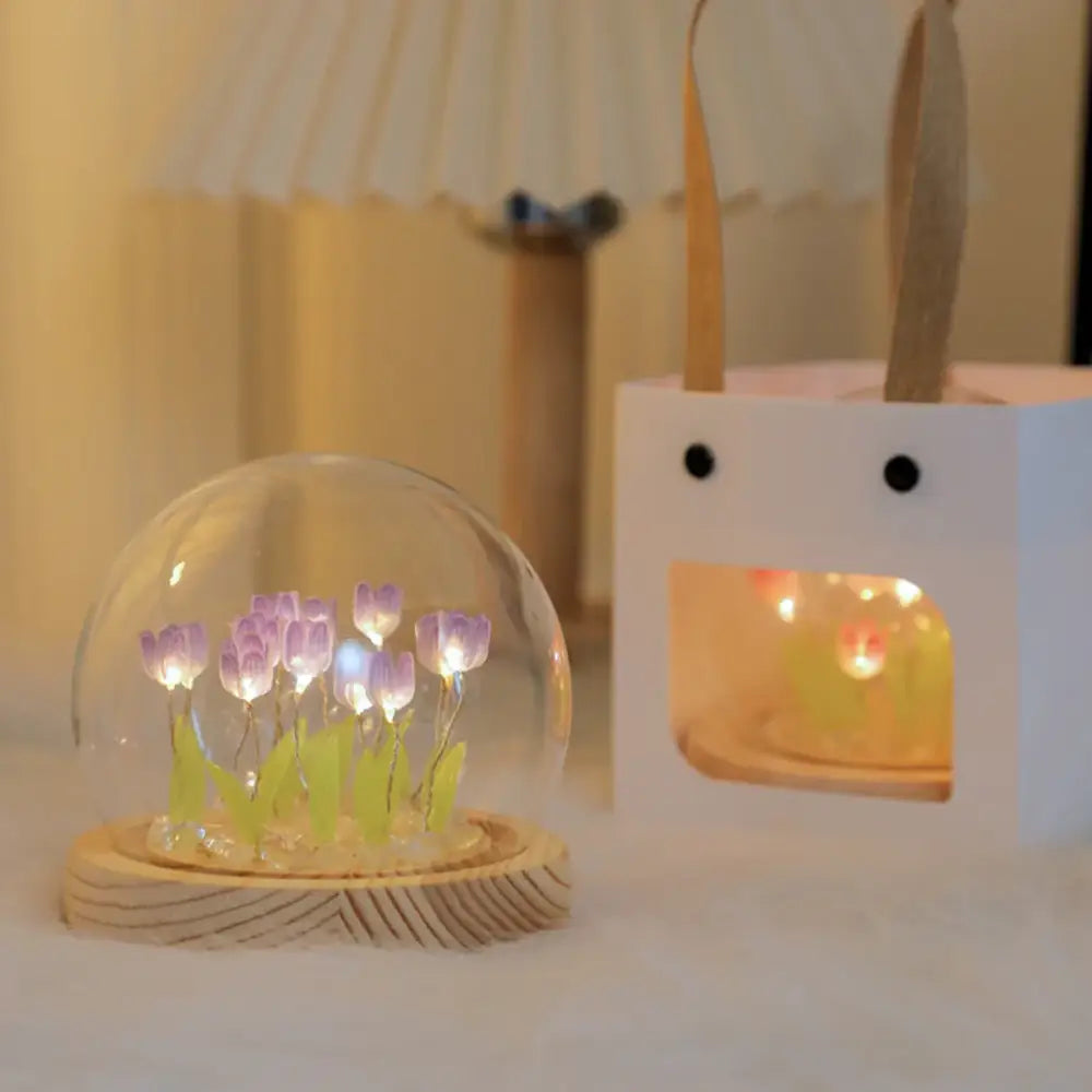 A clear glass dome with illuminated purple tulips on a wooden base decorbites tulip night light bedside lamp