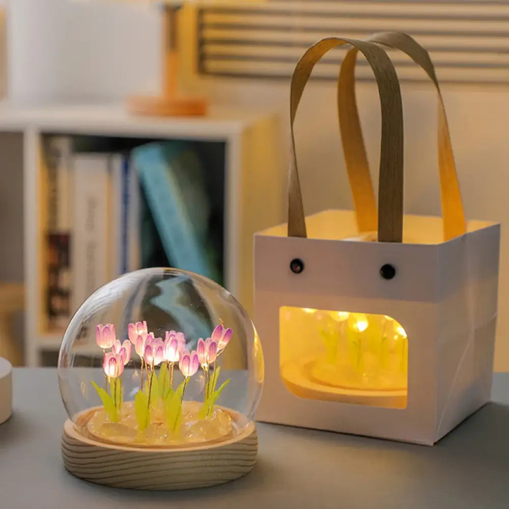 A clear glass dome with glowing pink tulips on a wooden base decorbites tulip night light battery operated bedside lamp