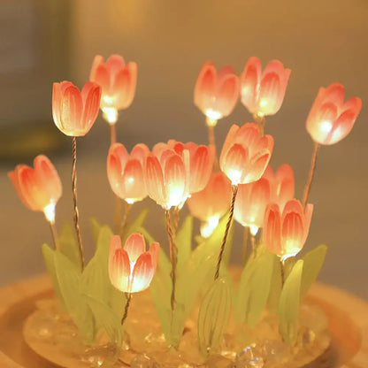 A cluster of glowing pink tulip night lights with green leaves on a decorative base battery operated bedside lamps