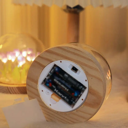 Wooden cylindrical tulip night light with natural grain finish and battery compartment for two aa batteries visible