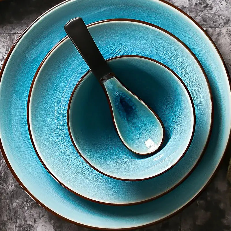 Set of three turquoise ceramic tableware set pieces with ice cracking glaze and dark brown rims with matching spoon