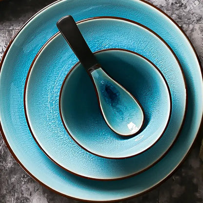 Set of three turquoise ceramic tableware set pieces with ice cracking glaze and dark brown rims with matching spoon