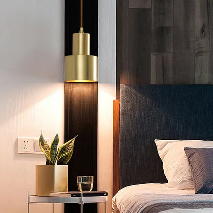 Two tier brass finish pendant light with gold-toned cylindrical design hanging above bedside table decorbites brass finish