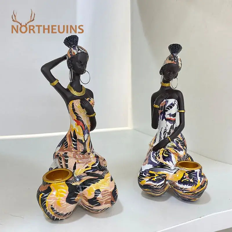 Two vibrant african black woman candlestick figurines with gold accents and patterned attire for living room decorbites black woman decor