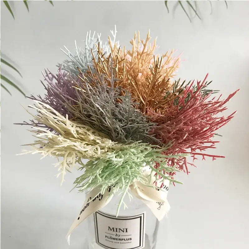 A vibrant multicolored dried flower bouquet in a white ceramic vase with decorative ribbon for living room decor