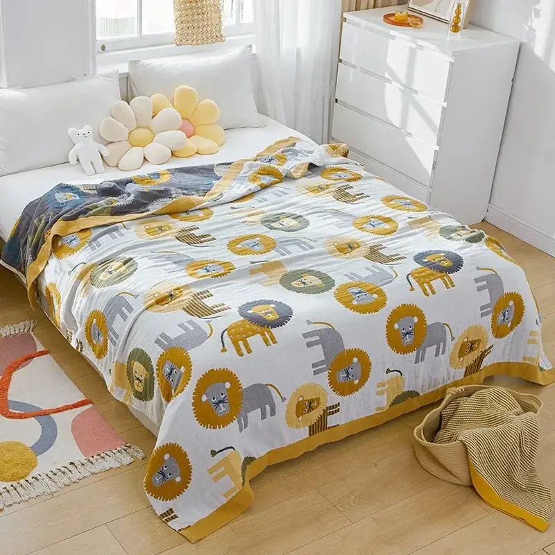 A soft white nordic throw blanket with playful lions and elephants pattern and a mustard yellow border