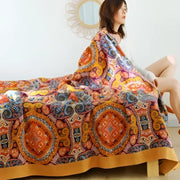 A vibrant orange and gold geometric nordic throw blanket with intricate patterns for bedroom bedspread use