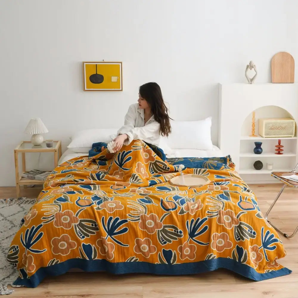 Vibrant orange and gold geometric nordic throw blanket with plush texture and navy blue floral accents for bedroom use