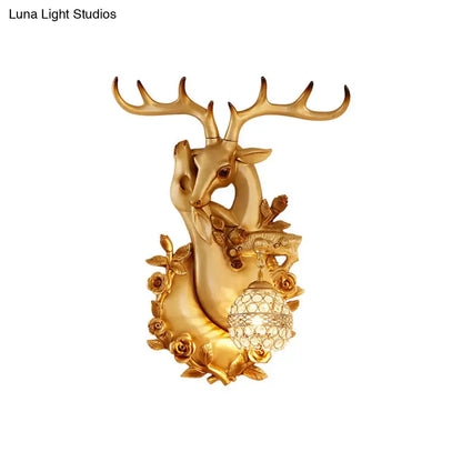 Golden deer head accent wall sconce with ornate antlers, rose embellishments, and crystal globe bedroom light