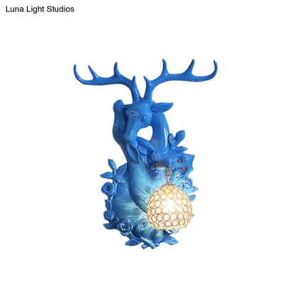 Vibrant blue deer head accent wall sconce with intricate antlers and warm spherical lampshade for bedroom lighting
