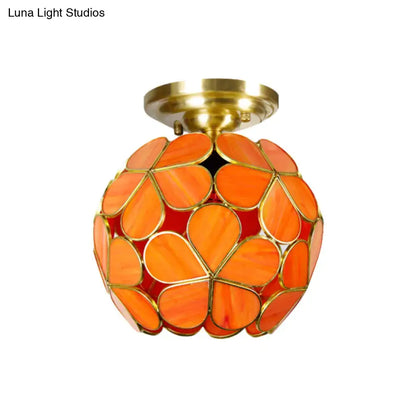 Vibrant orange stained glass flower ceiling light with brass fixture and petal-shaped panels by decorbites