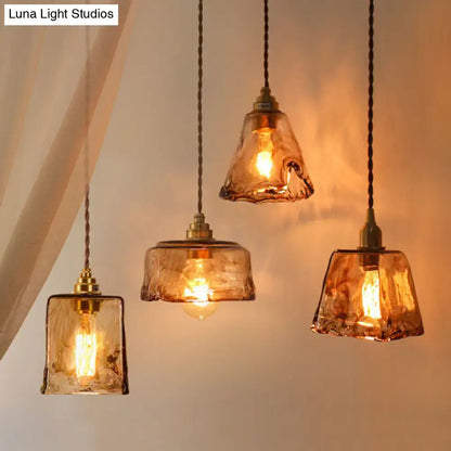 Three amber alabaster glass pendant lamps with brass accents hang from twisted cords for living room lighting