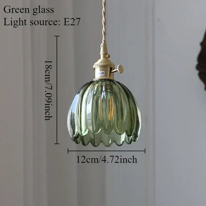 A delicate green glass pendant light with fluted design and brass hardware paired with dining room iron finish