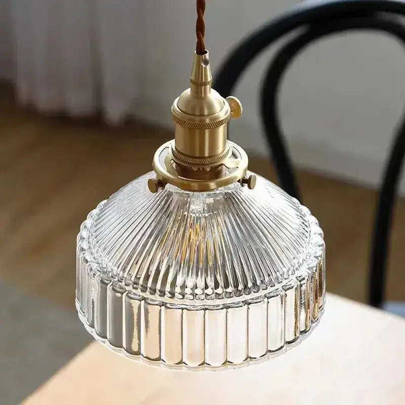 Vintage amber colored glass pendant light with brass fixture and ribbed textured design for dining room use