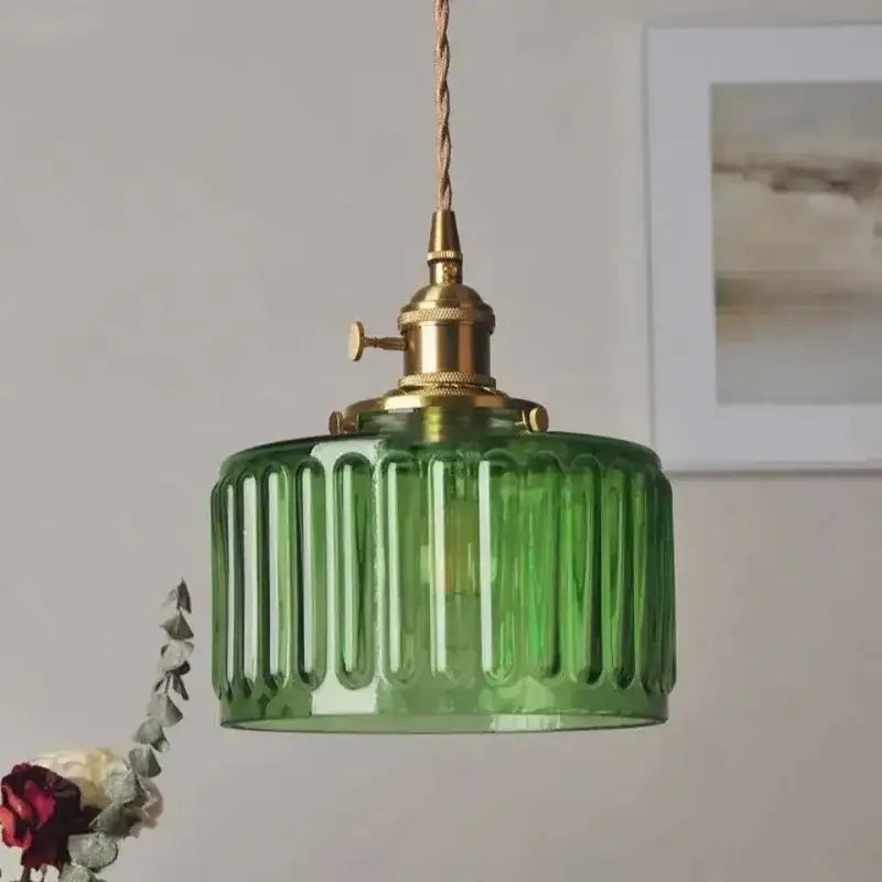 Green ribbed colored glass pendant light with brass-finished metal fixture and twisted cord for dining room use