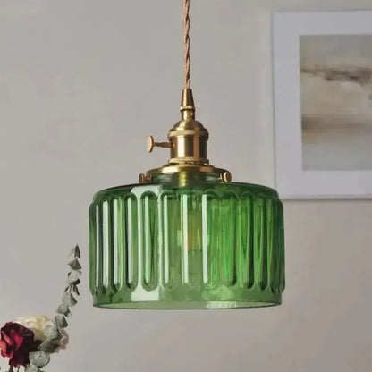 Green ribbed colored glass pendant light with brass-finished metal fixture and twisted cord for dining room use