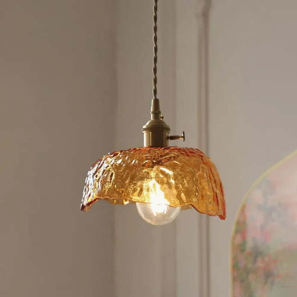 Vintage amber glass pendant light with textured amber glass, brass fixture, and twisted cord for kitchen island lighting