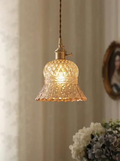 Vintage amber glass pendant light with warm-toned intricate patterns and brass fixture for kitchen island lighting