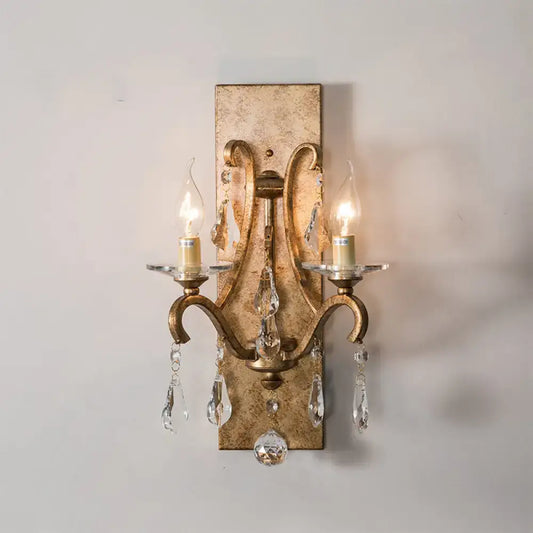Antique gold-finished wall lamp with dark purple clear crystal droplets and candle-style bulbs for bedroom sconce