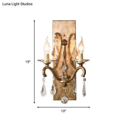Antique gold-finished wall lamp sconce with two candle-style bulbs and dark purple clear crystal teardrop pendants