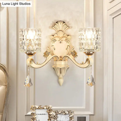 Elegant cream-colored vintage glass wall light with gold accents and two faceted crystal shades for bedroom use