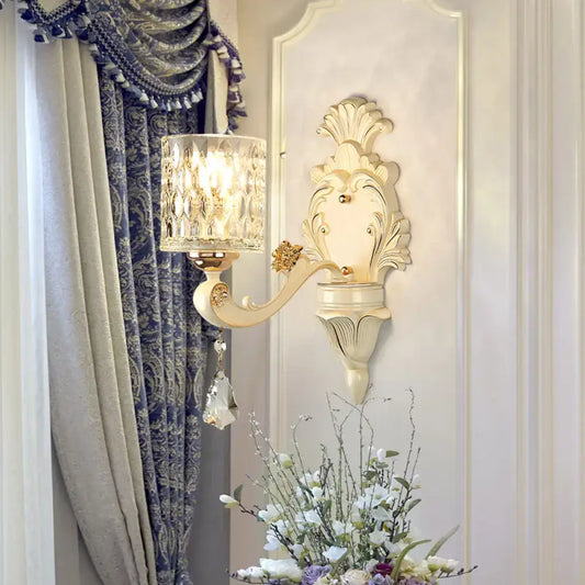 Cream-colored ornate vintage glass wall light with faceted crystal shade and gold accents for bedroom use