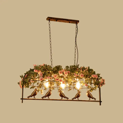 Vintage bird cage iron hanging light featuring five bronze bird figurines under pink rose arch for dining room use