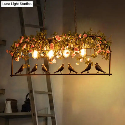 Vintage bird cage iron hanging light with six bronze birds, pink roses, and greenery for dining room decor