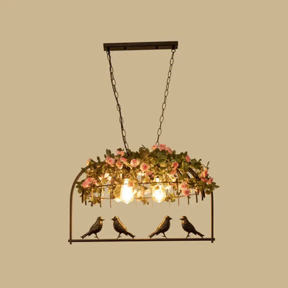 Vintage bird cage iron hanging light with black metal frame pink roses greenery and three exposed bulbs with bird figurines