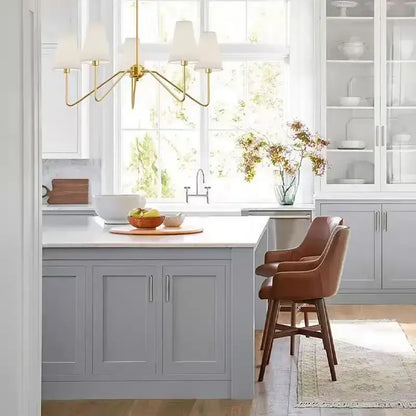 Brown leather barstools with wooden legs paired with a vintage black and gold iron finish cloth shade pendant light dining room chandelier