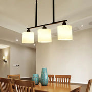 Vintage black metal bar island light with three off-white fabric shades for dining room white glass decor