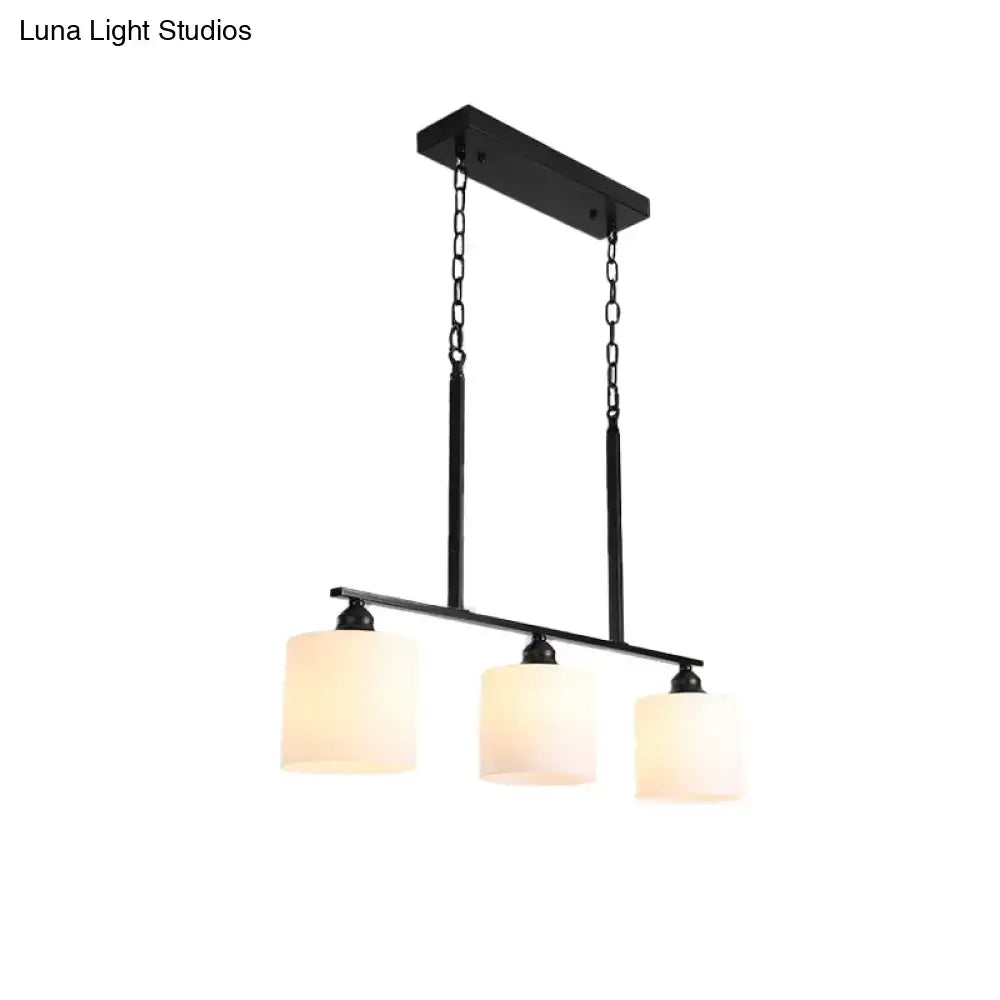 Vintage black metal island light with three cylindrical white frosted glass shades for dining room use