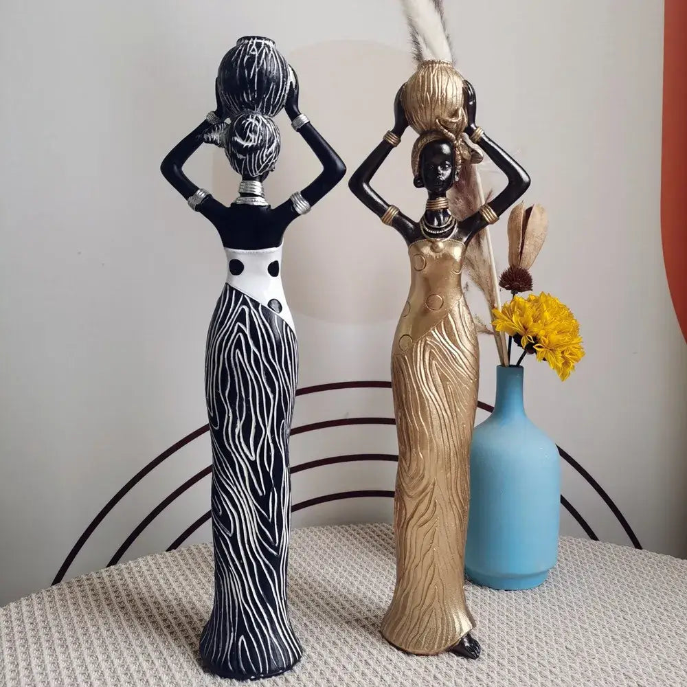 Two stylized african women resin sculptures in black white zebra skirt and gold wood grain for living room decorbites decor