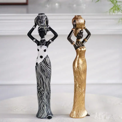 Two elegant african women resin sculptures in black and white zebra stripes and smooth gold finish for decorbites decor