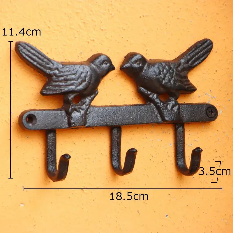 Vintage black iron bird hook wall shelf featuring two detailed birds and three hooks for entryway storage
