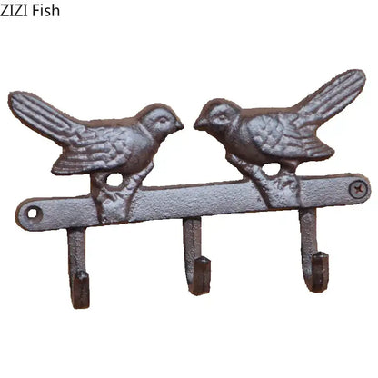 Vintage black iron bird hook wall shelf with two detailed birds and three hooks in rustic gray patina for entryway storage